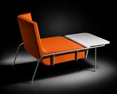 une chaise orange et une table blanche dans une pièce sombre