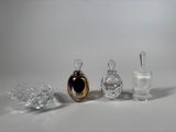 three glass perfume bottles sitting next to each other on a white surface