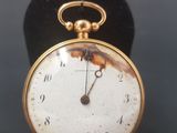 an old pocket watch sitting on top of a black velvet case