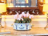 un vase avec des fleurs posé sur une table devant un miroir