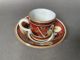a cup and saucer sitting on a saucer on a table