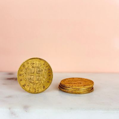 two gold coins sitting on top of a marble counter top