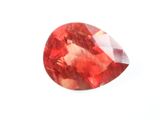 un gros plan d'un diamant rouge sur une surface blanche