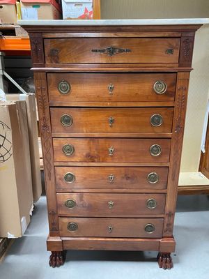 a tall wooden chest of drawers in a store