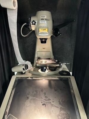 une machine posée sur une table, à côté d'un rouleau de papier toilette