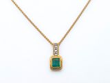 an emerald and diamond pendant on a gold chain