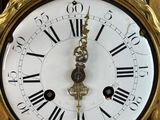 a gold clock with roman numerals on the face of it