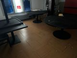 two tables and two chairs in a room with a window