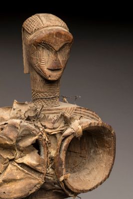 un gros plan sur une statue en bois représentant une personne coiffée d'un chapeau