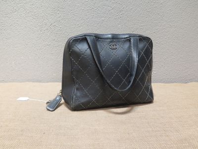 un sac à main noir posé sur une table près d'un mur