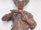 une statue en bronze représentant un garçon coiffé d'un chapeau