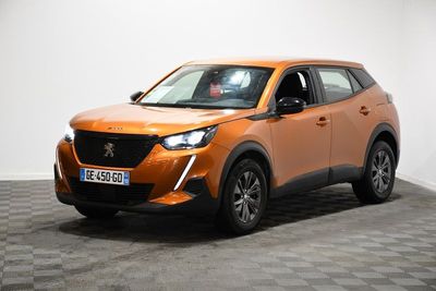 La voiture orange est garée dans une pièce dont le sol est à carreaux.