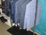 a rack of shirts hanging on a clothes rack in a room