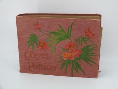 un vieux livre orné de fleurs rouges et de feuilles vertes