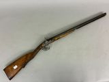 un fusil avec une poignée en bois sur une surface blanche