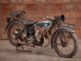 a old motorcycle that is parked in front of a brick wall