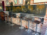three stools that are sitting in front of a brick wall
