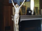 une statue de Jésus sur une croix devant une cheminée