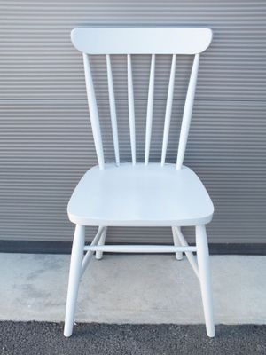 une chaise blanche posée devant un mur