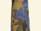a yellow vase with blue flowers on it on a white background