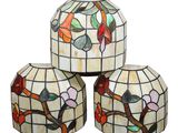 three stained glass lamps sitting on top of each other on a white surface