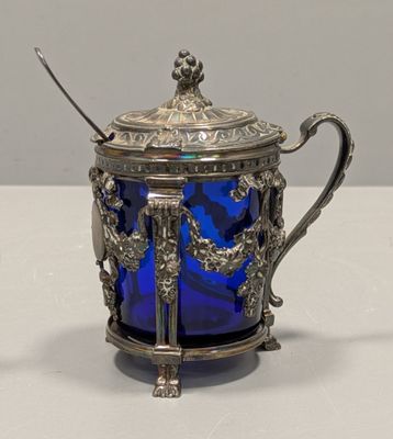 une théière en verre bleu contenant une cuillère