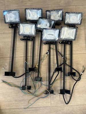 six projecteurs posés sur un plancher en bois, auxquels sont rattachés de nombreux fils électriques
