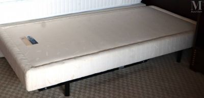un petit lit avec un matelas posé dessus, dans une chambre