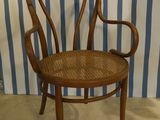 a wooden chair that is sitting in front of a blue and white striped wall