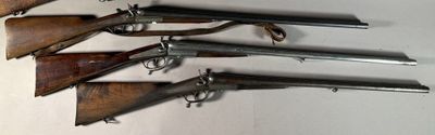 several old guns are lined up on a wall in a room