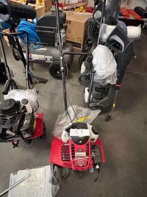 Plusieurs tondeuses à gazon sont rangées dans un garage