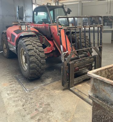 a red tractor that is parked in a garage