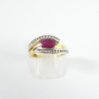 gros plan d'une bague en or avec un rubis et des diamants