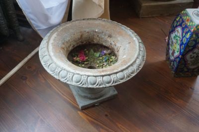 un vase rempli de fleurs posé sur un parquet