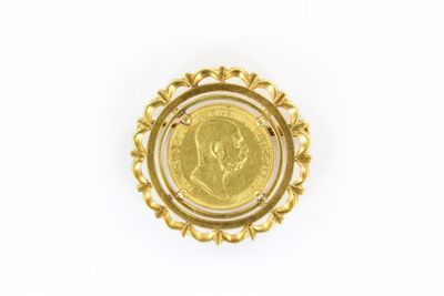 a close up of a coin in a gold ring on a white surface