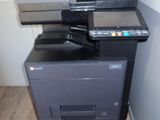a multi - function printer sitting on top of a black cabinet