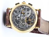 a close up of a watch on a white surface