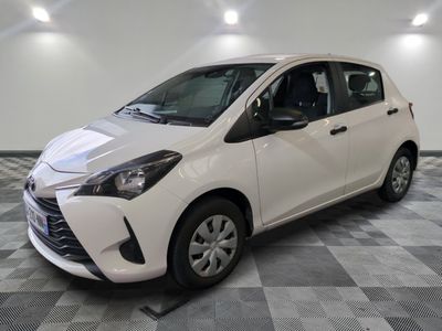 the white toyota yaris is parked on a checkered tile floor