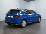 the rear end of a blue car parked in a garage