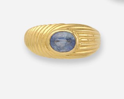 une image d'une bague en or avec une pierre bleue au centre