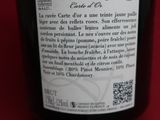 a bottle of wine that is on a red table