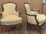 pair of antique upholstered chairs in a room with wood flooring