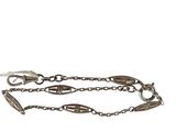 a close up of a chain bracelet with a bird on it