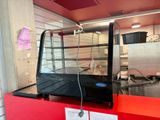 a glass display case with a red counter in a kitchen