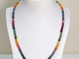 un gros plan d'un collier composé de perles multicolores porté par un mannequin