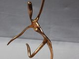 bronze sculpture of a woman holding a tennis racquet on a base