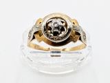 une bague sertie d'un diamant, posée sur une surface transparente