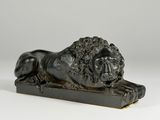 a bronze statue of a lion on a wooden base