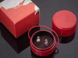 une boîte rouge et une paire de boucles d'oreilles posées sur une table