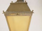 an old fashioned light hanging from the side of a wall